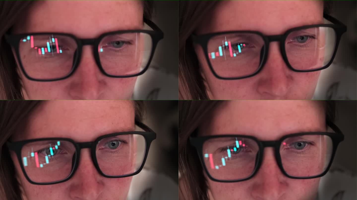 Сlose一名戴眼镜的女子注视着不断变化的数字、股票和金融图表