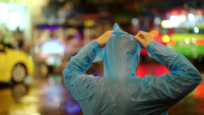 一个年轻人站在雨中的路上