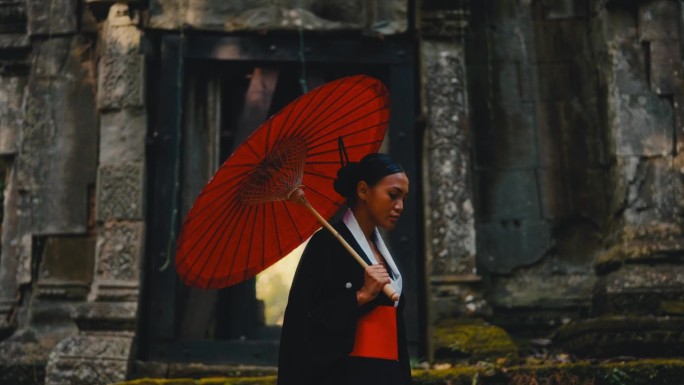 手持红伞的女子在庙里散步