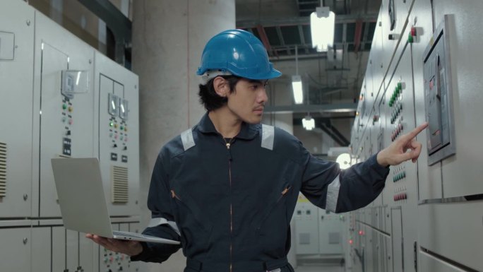 一名电工工程师在工业工厂的控制室、操作站网络中检查和记录电气保护继电器参数。