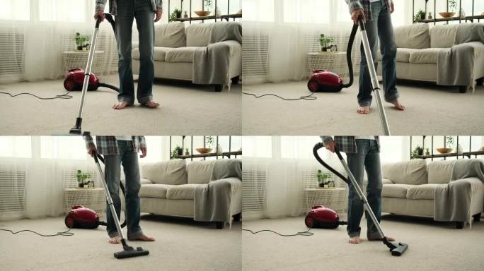 在客厅用真空吸尘器清理地毯的男人
