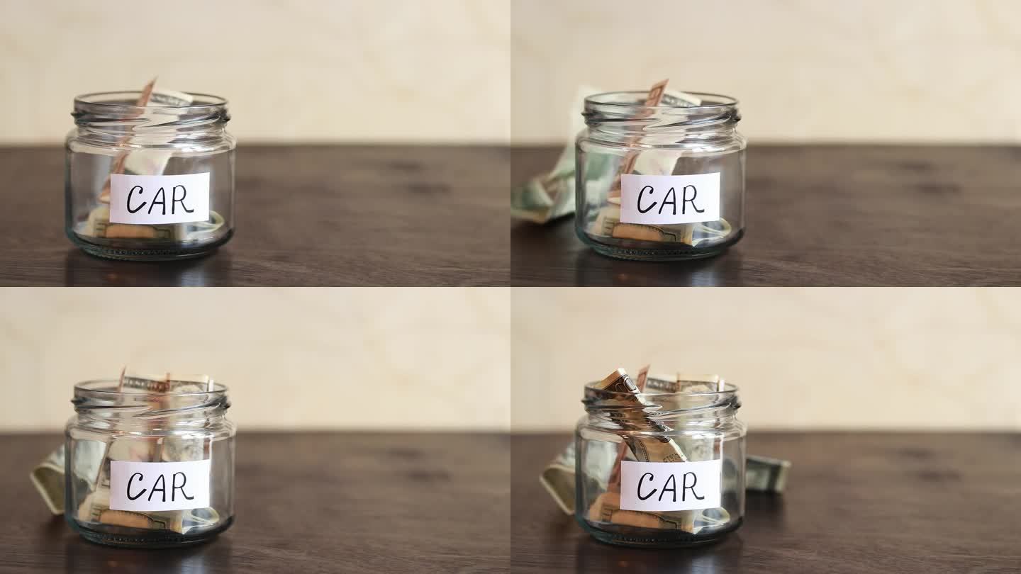 桌子上放着钱的玻璃罐特写。存钱罐里的钱用来买车