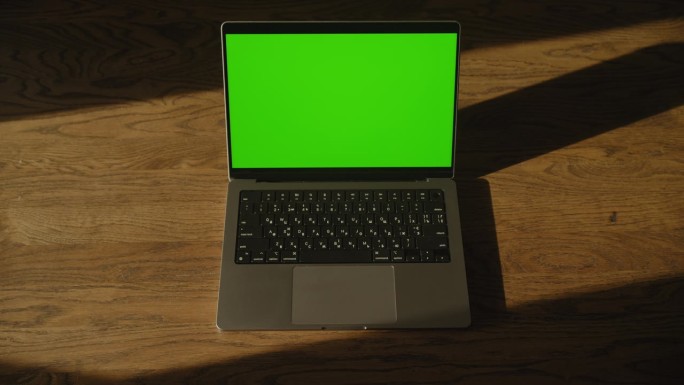 俯视图笔记本电脑绿屏。手按Enter键。