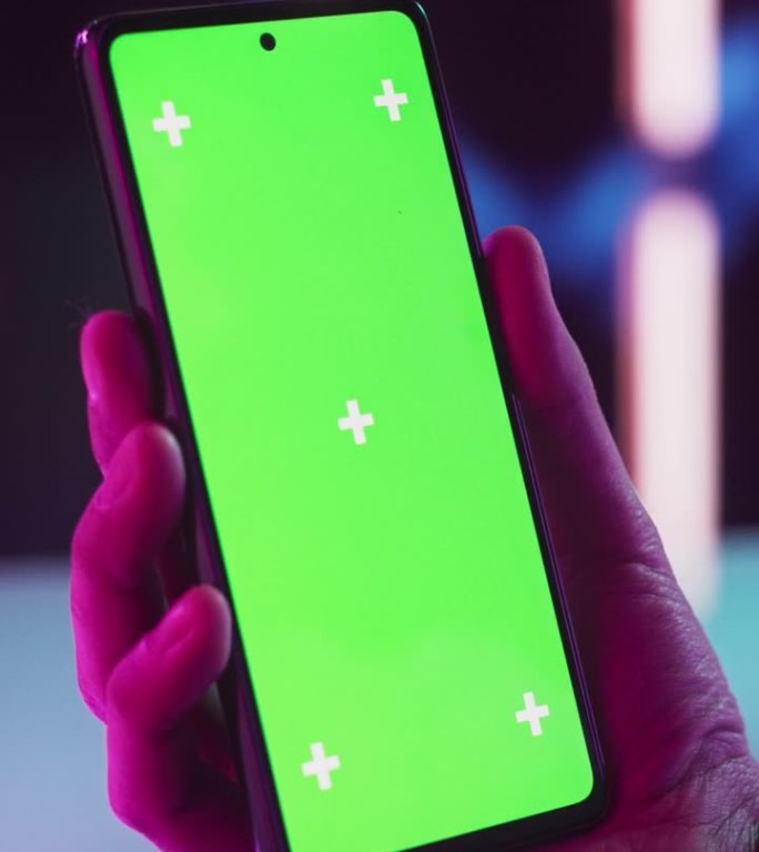 垂直屏幕:时髦的人拿着智能手机，看着绿色模拟显示屏的屏幕。视频模板与数字营销，视频游戏，应用程序，网