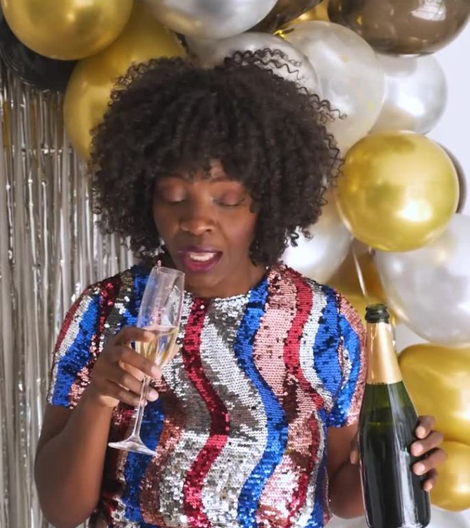 非洲妇女在聚会上用酒瓶而不是玻璃杯喝香槟。