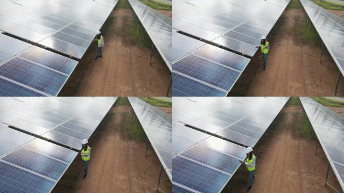 无人机拍摄的太阳能工程师在太阳能农场工作。