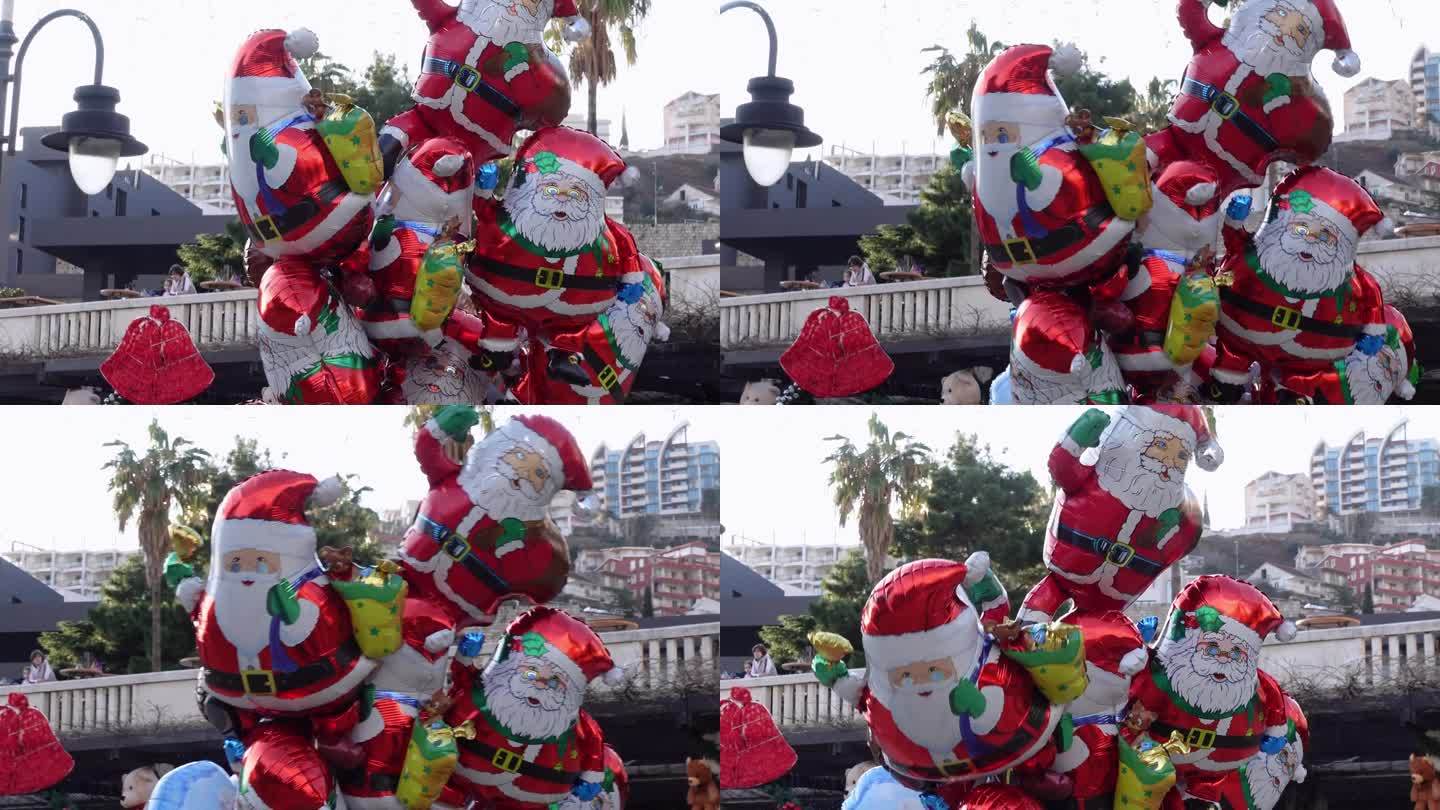 充气圣诞老人球被捆成一捆，在街上随风摇摆