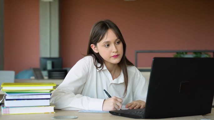 专注的女生在课堂上使用笔记本电脑，有吸引力的女生学习语言，观看在线网络研讨会，听音频课程，电子学习教
