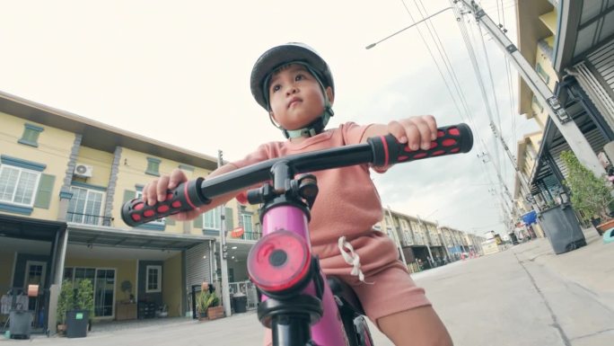 蹒跚学步的孩子骑着平衡自行车。