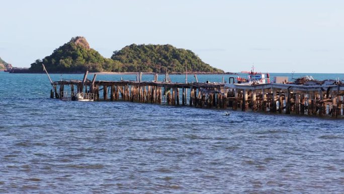 一个木制捕鱼码头延伸到大海的海景。木桥伸入大海，景色宜人。