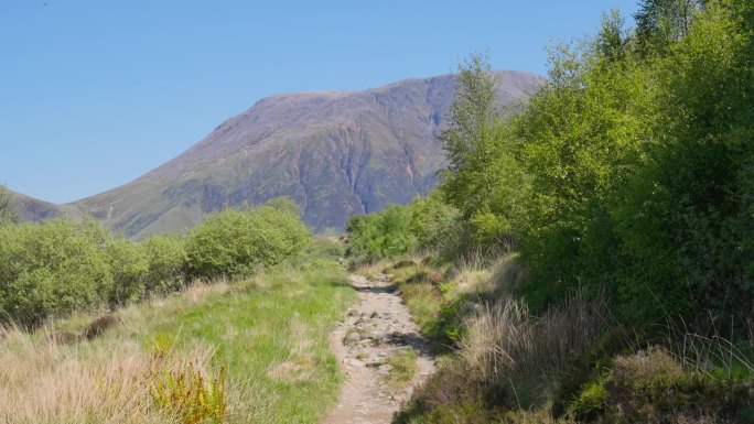 在苏格兰一个阳光明媚的日子里，空旷的荒野砾石小径延伸到本尼维斯山
