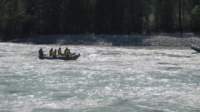 一群人乘坐木筏沿着湍急的山河顺流而下