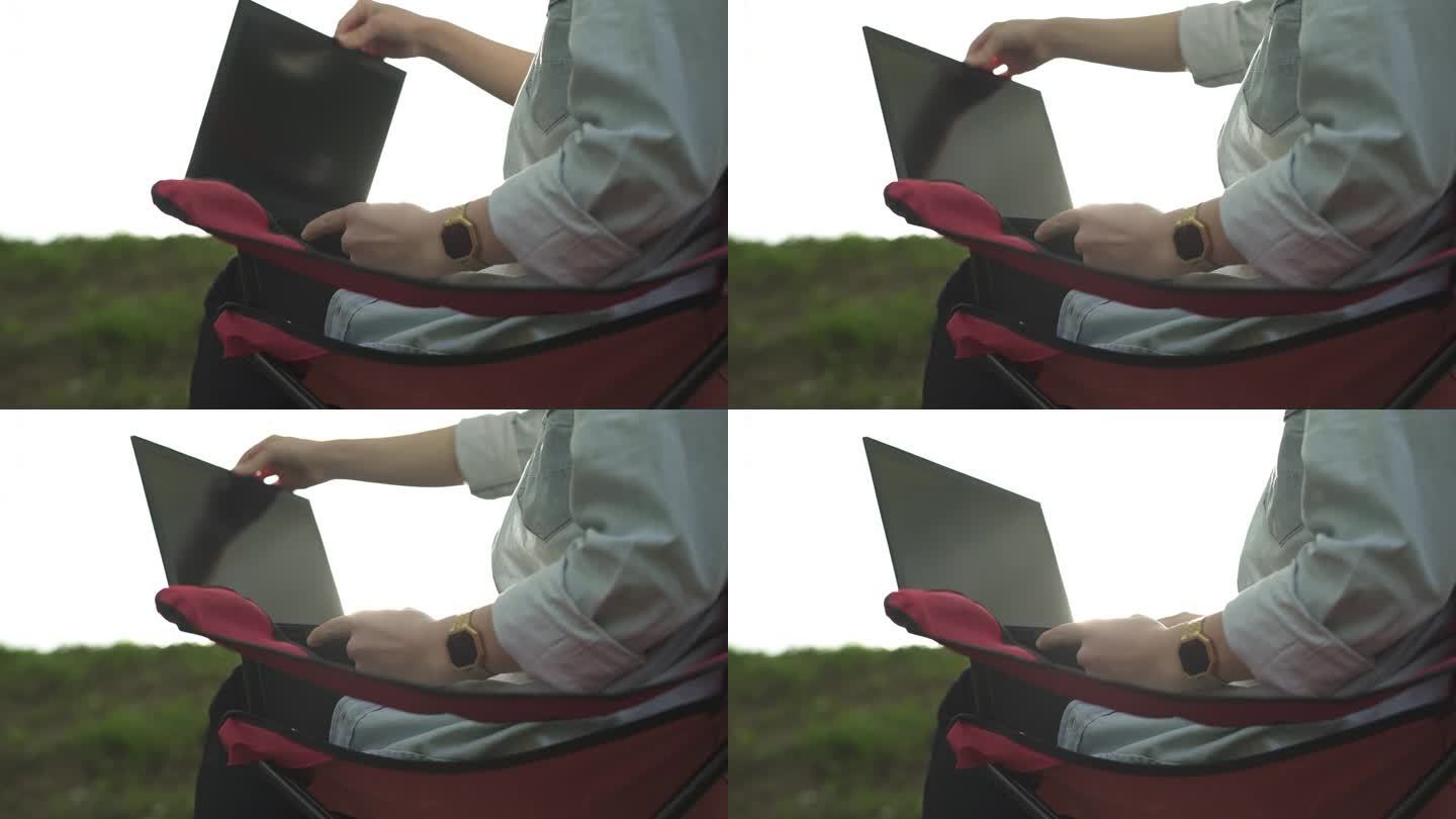 戴头巾的年轻女子在自然公园打开笔记本电脑