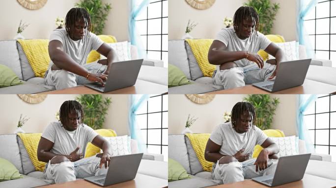 患有胃痛的非洲裔美国人在家里使用笔记本电脑