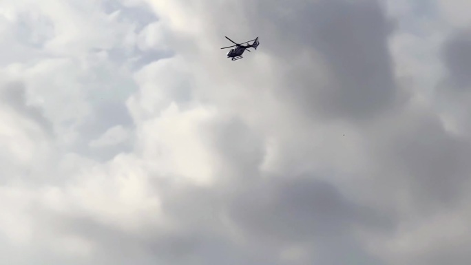 警用直升机在多云的天空下飞行