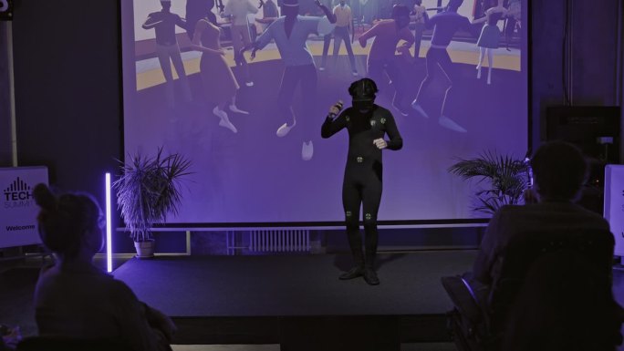 日本男子在科技会议舞台上与虚拟现实互动。