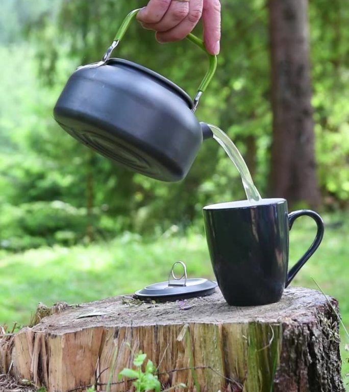 野菜茶是在露营地的森林里调制的。垂直视频
