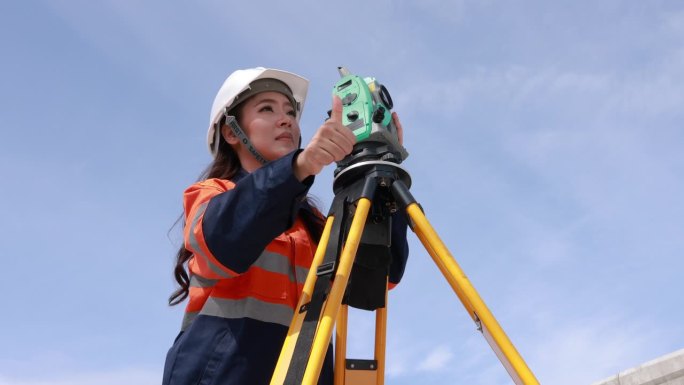 女工程师使用经纬仪设备进行路线测量，在十字路口搭建桥梁，以减少高峰时段的交通拥堵。