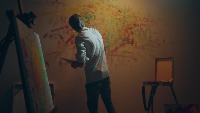 在镜头前，艺术家用他的手指在墙上画新的画面，当代和现代艺术作品