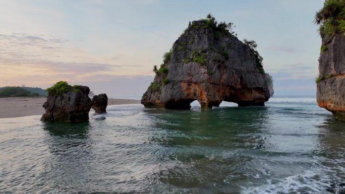 空中无人机拍摄的日出场景:印尼西松巴岛的瓦图马东海滩，岩石形成的碰撞波