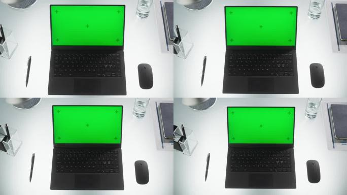 笔记本电脑的顶部缩放视图，模拟绿屏Chromakey显示器与运动跟踪器站在办公室桌子旁边的无线鼠标，