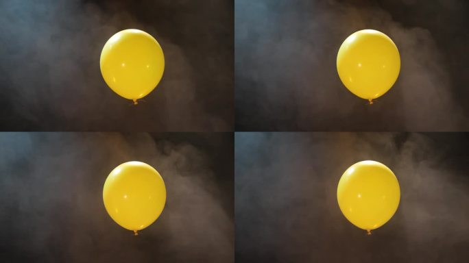 黄色充气球在黑暗的背景与烟雾