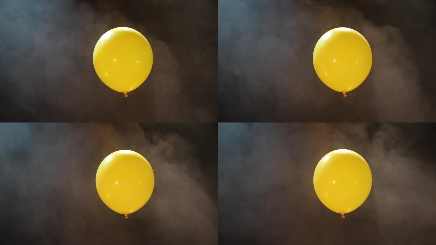 黄色充气球在黑暗的背景与烟雾