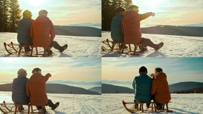 一对老年夫妇在日落时坐在雪橇上欣赏风景