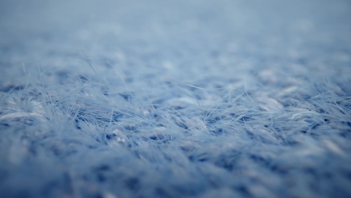 微距毛线面料，针织毛线套头衫。滑杆小车极近距离服装材料蓝色羊毛，羊毛纤维。冬衣面料质感
