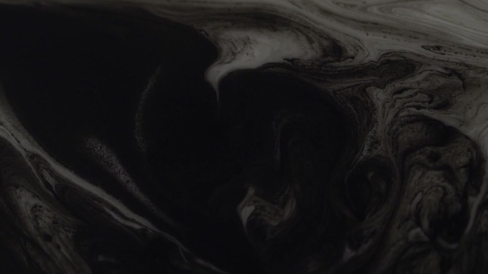 一滴黑色墨水在液体中扩散的特写