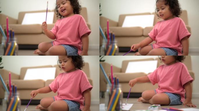 快乐的时刻，小可爱的女孩在客厅用画笔在框架画布上创作和水彩画活动。孩子们的活动。儿童身体、情感、认知