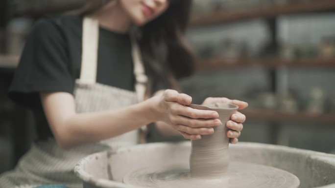 十几岁的女孩正在制作陶器作为休闲活动。