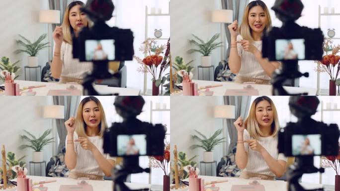 亚洲博主女性在家里的网站或社交媒体上向订阅者录制化妆教程，展示评测眼影化妆品，博主用摄像机直播视频频