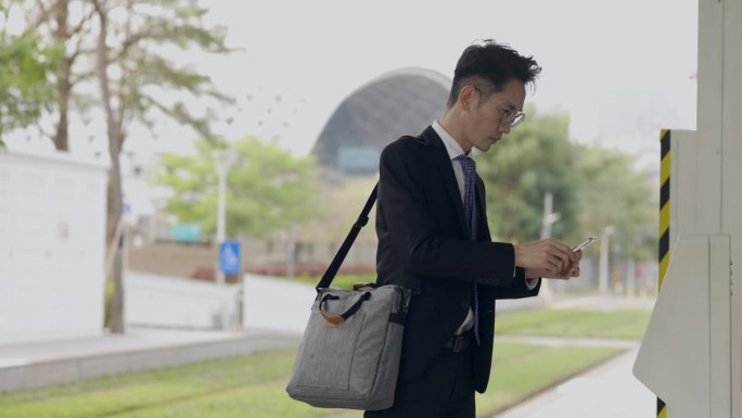 一名亚洲男性正在用手机里的数字钱包支付地铁通勤票。