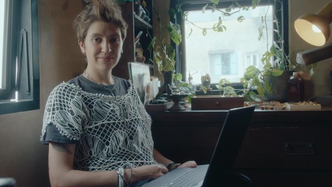年轻女子用笔记本电脑在古董店拍照