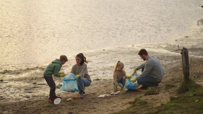家庭野餐后从河边收集塑料垃圾，生态志愿者拯救地球
