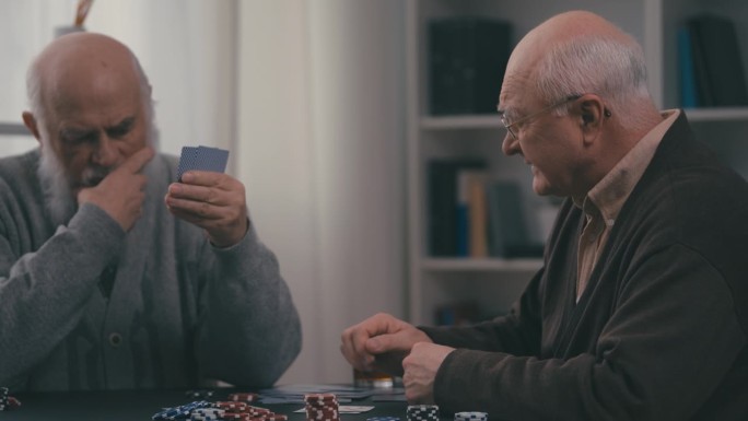 一位老人在和他的老朋友玩扑克游戏时赢得了胜利