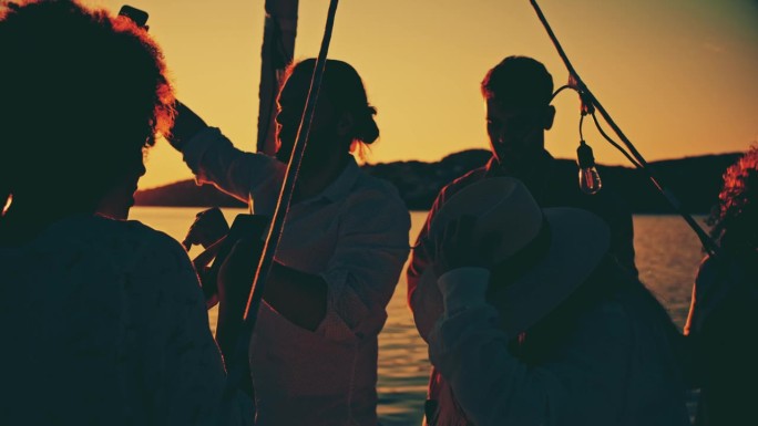 一群朋友在船上聚会跳舞，用手机拍照的剪影