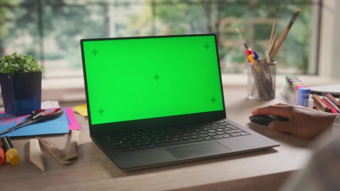 匿名非洲设计师在笔记本电脑上工作，模拟绿色屏幕Chromakey显示与孤立的占位符。用于艺术内容创作