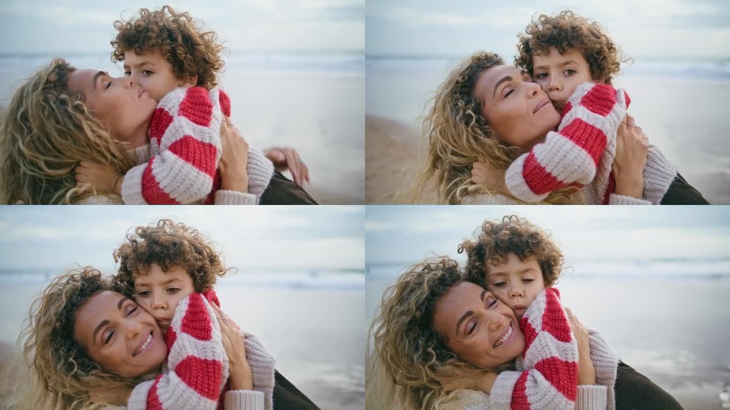 快乐的母亲抱着儿子在秋天的海边特写。真挚的亲情