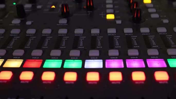 声音控制台面板上闪烁的灯光，数字音频混音器特写