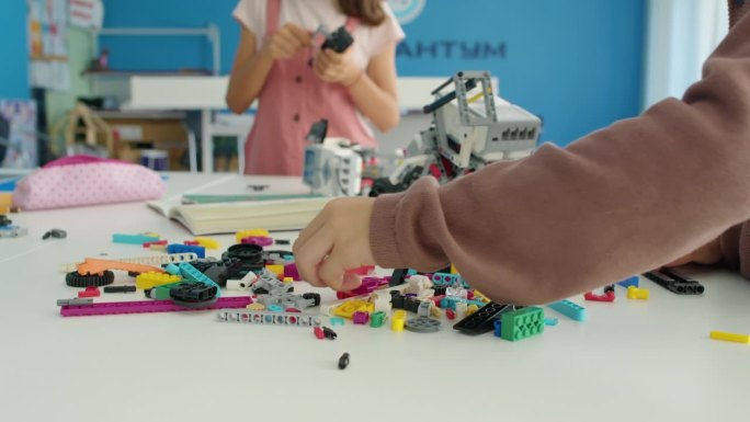 孩子们用塑料积木制作机器人的手在业余爱好俱乐部