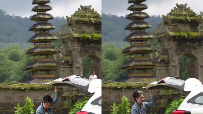 亚洲，印尼，巴厘岛，亚洲一家人停下车享受旅行，在Tamblingan水庙前，一边观光。