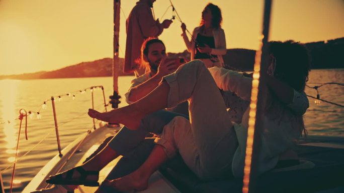 一名男子在游艇派对上拍摄两位女性朋友相互拥抱的照片