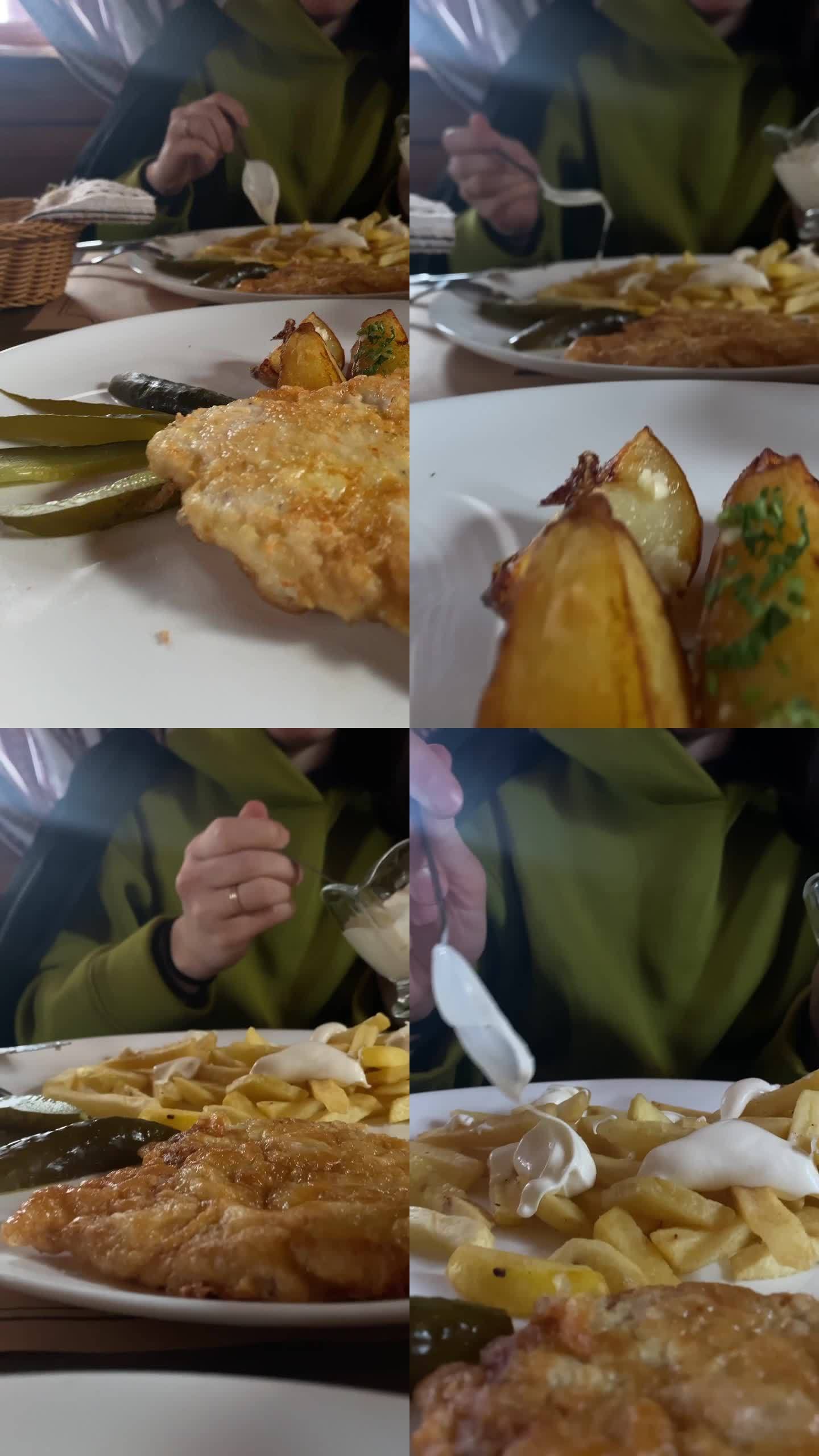 靠近盘子里的食物在餐馆里吃土豆的女人
