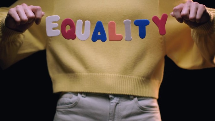 白人妇女举着彩色字母的“平等”，慢动作