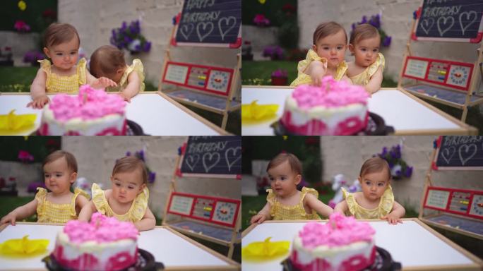 双胞胎姐妹一起庆祝她们的一岁生日，吃着生奶油