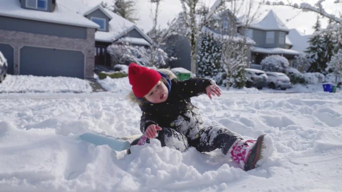 可爱的小女孩在她家门前的雪地里玩耍