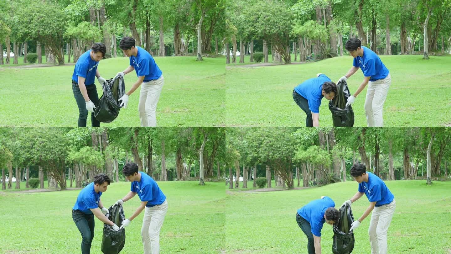 多民族志愿者拿着黑色垃圾袋收集塑料垃圾，以减少公园的污染。