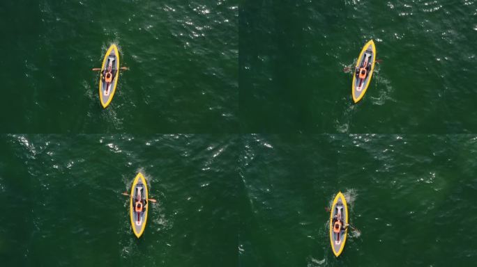 无人机拍摄的一名男子在开阔的海面上划着独木舟的俯视图。